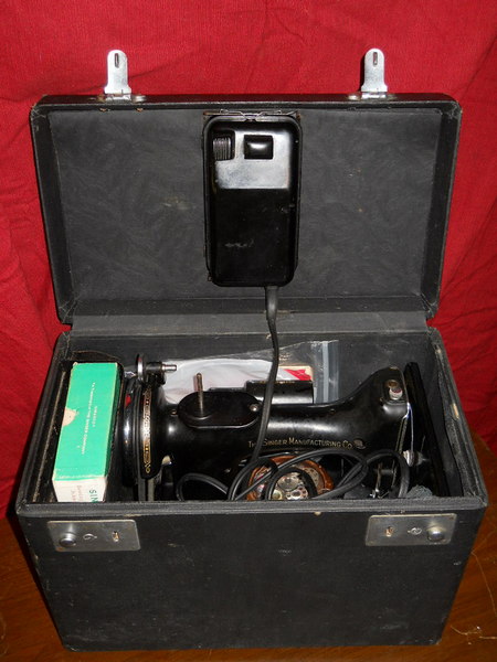 black box open with a black sewing machine inside