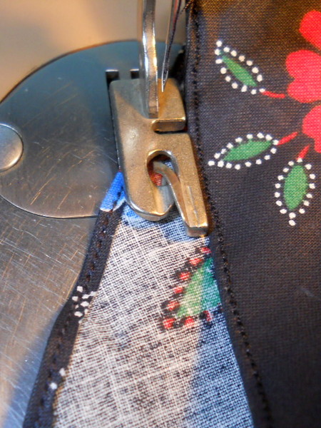 close up of the presser foot and tablecloth hem
